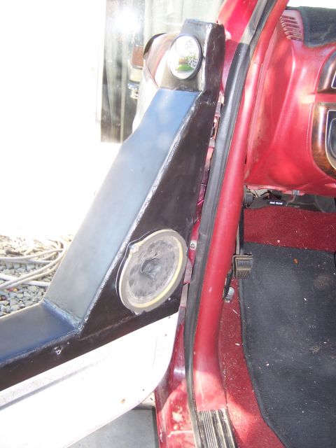 1991 Ford Bronco - Interior view of a vehicle's door panel with a speaker and a side mirror, showing part of the dashboard.
