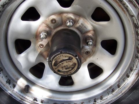 1991 Ford Bronco - A close-up view of a Warn manual locking hub on a vehicle's wheel, indicating its operational settings.