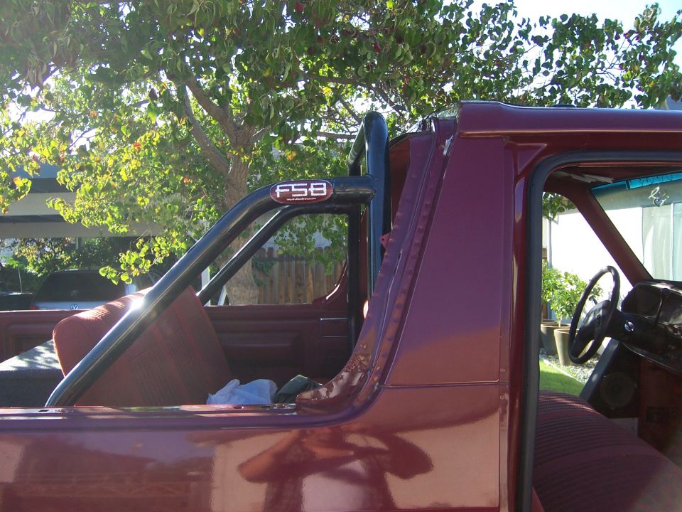 Maroon 1991 Ford Bronco interior with a black FSB roll bar and red seats
