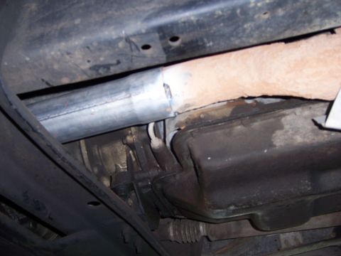 1991 Ford Bronco - Underbody view of a vehicle's exhaust system and transmission pan, with a section of the exhaust pipe repaired.