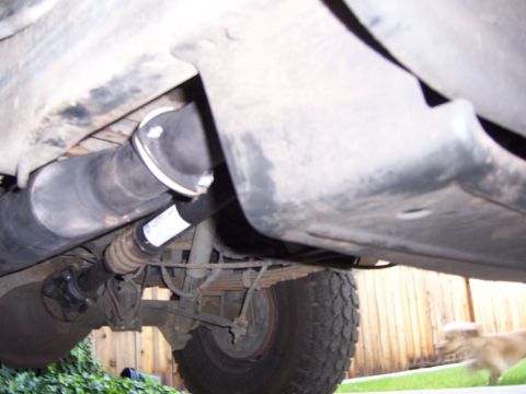 1991 Ford Bronco - Close-up view of the underbody of a vehicle, focusing on the driveshaft and suspension components. A label is visible on the driveshaft.