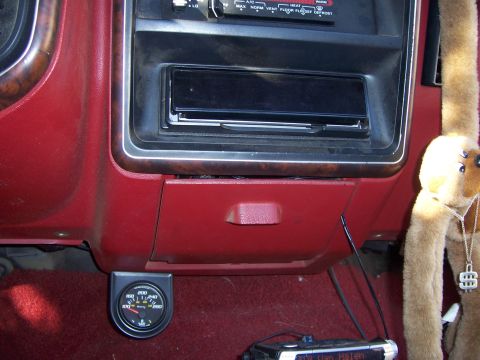 1991 Ford Bronco - The interior of a 1991 Ford Bronco shows a red dashboard with wood trim, an aftermarket stereo, and a temperature gauge mounted below the g…