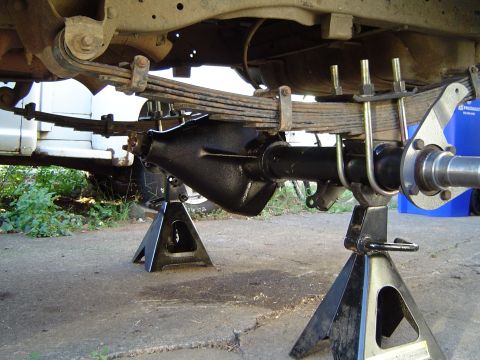 1978 Ford Bronco - Rear axle assembly supported by jack stands, showing leaf springs and U-bolts.