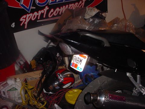 2004 Yamaha FZR600 - Rear view of a motorcycle, showing license plate, helmet, and exhaust pipe. Banner in background.