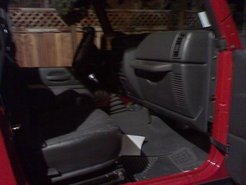 1994 Ford Bronco - The interior of a red vehicle, possibly a Jeep Wrangler, is visible with the door open.