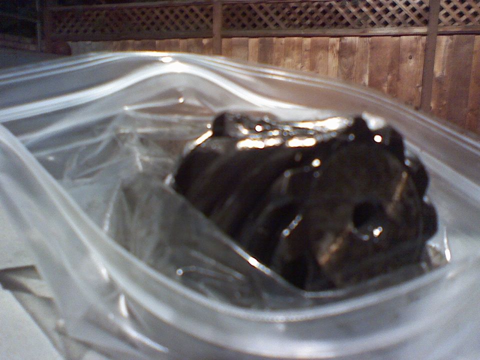 Dark engine component inside a clear plastic bag