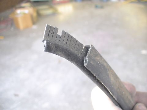 1993 Ford C-350 (Centurion Conversions) - A damaged rubber seal, possibly from a vehicle, is held up for inspection.