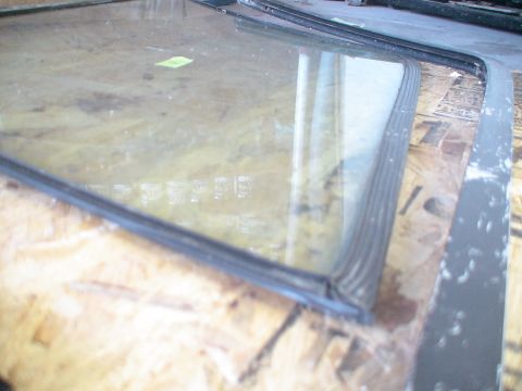 1993 Ford C-350 (Centurion Conversions) - A detached window seal with a rubber gasket is shown in close-up, lying on a wooden surface.