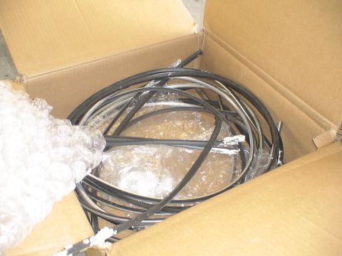 1993 Ford C-350 (Centurion Conversions) - A cardboard box contains a jumble of black rubber seals and metal trim pieces, some with bubble wrap.