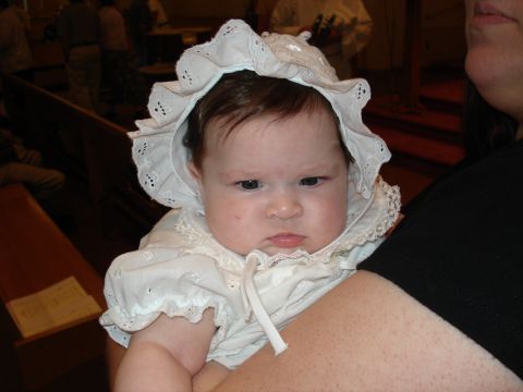 2000 Ford Crown Victoria - A baby wearing a bonnet and dress is held by an adult.