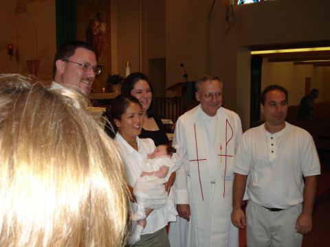 2000 Ford Crown Victoria - A group of people, including a priest, gather for a baptismal ceremony.