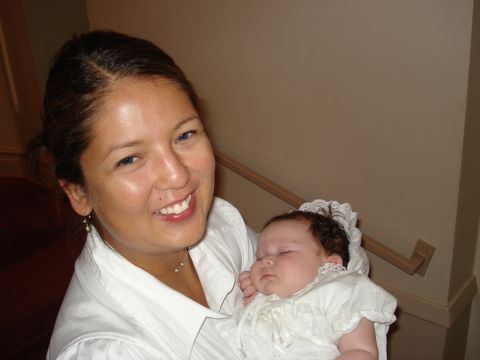 2000 Ford Crown Victoria - A woman smiles while holding a baby dressed in a christening gown.