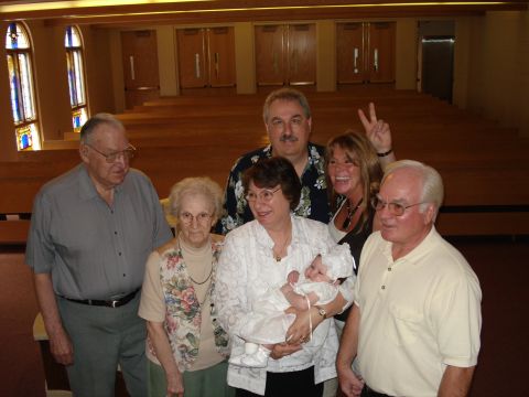 2000 Ford Crown Victoria - A family gathers for a special occasion, with a baby being held by one of the adults.