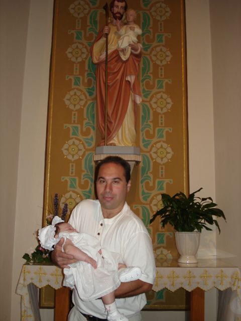 2000 Ford Crown Victoria - Man with baby in front of religious statue and altar.