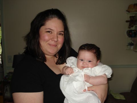 2000 Ford Crown Victoria - A woman smiles while holding a baby dressed in white.