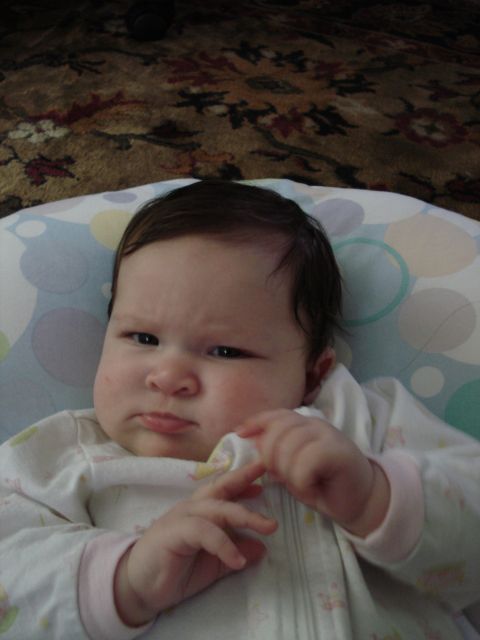 2000 Ford Crown Victoria - A baby looks unimpressed while lying on a patterned pillow.