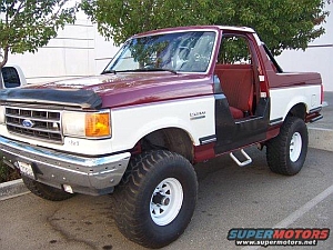 1986 Ford Bronco - This two-tone Ford Bronco features a removable top and a lifted suspension, seen here from the front three-quarter angle.