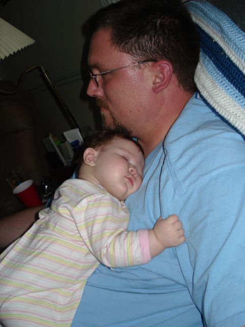2000 Ford Crown Victoria - A father holds his sleeping baby daughter close, creating a tender moment of rest.