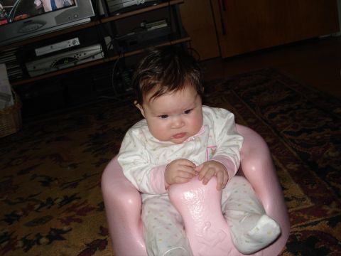 2000 Ford Crown Victoria - A baby sits in a pink seat, looking down with a thoughtful expression.