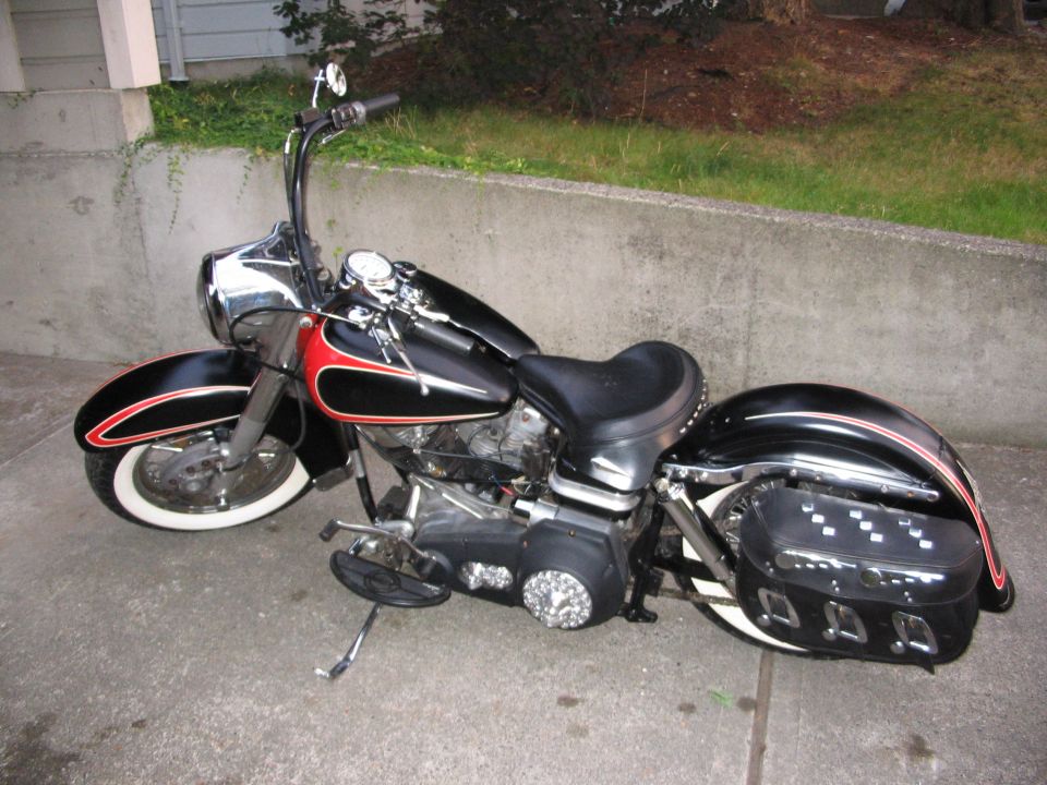 Black classic V-twin cruiser motorcycle with whitewalls and leather saddlebags, side view