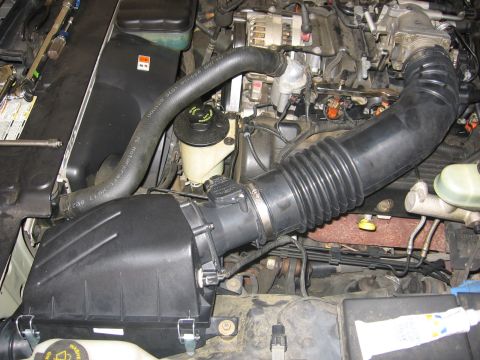 2000 Ford Crown Victoria - Close-up view of a vehicle's engine bay, focusing on the air intake and associated components.