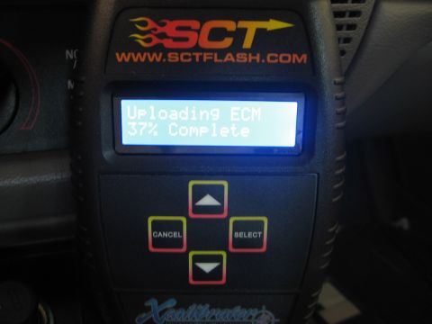 2000 Ford Crown Victoria - An SCT XCalibrator 2 tuning device is shown in a vehicle's interior, displaying an ECM upload progress.