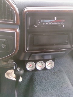 1990 Ford Bronco - Close-up of the dashboard interior, showing auxiliary gauges and the gear shifter.