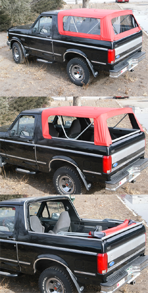 1990 Ford Bronco - This black Ford Bronco features a red soft top and is shown from a three-quarter front angle.
