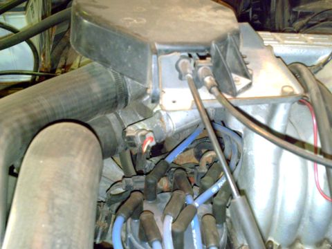 1990 Ford Bronco - Close-up view of engine components, including a distributor cap and spark plug wires, with a watermark at the bottom right.