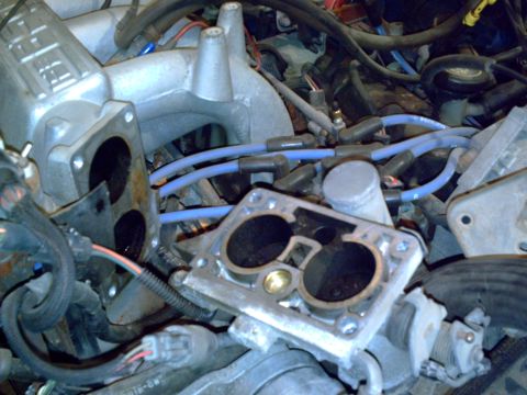 1990 Ford Bronco - Close-up view of engine components, including an intake manifold and throttle body.