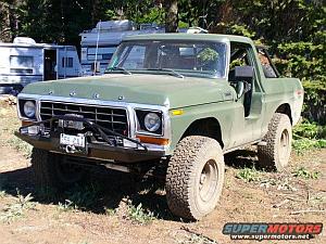 1986 Ford Bronco - This green Ford Bronco, likely a 1978 or 1979 model, is equipped with an aftermarket bumper and large off-road tires.