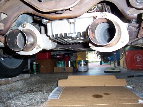 1978 Ford Mustang II - The rear differential and dual exhaust pipes are visible from underneath the vehicle, with various items in the background.