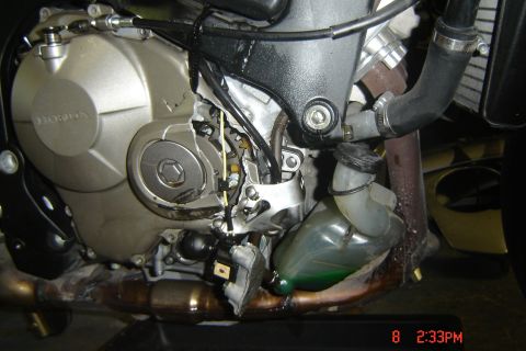 2006 Honda CBR-RR - The engine casing appears to be cracked and damaged, with wires and hoses exposed.
