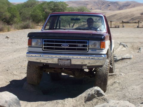 1991 Ford Bronco - Ford Bronco navigating rocky terrain on a sunny day.