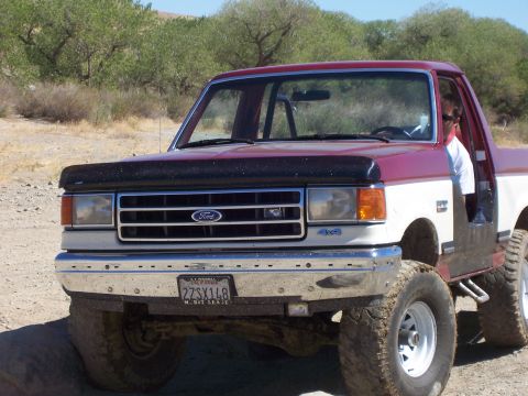 1991 Ford Bronco - Front view of a 1987 Ford F-150 pickup truck with a two-tone paint job and off-road tires.