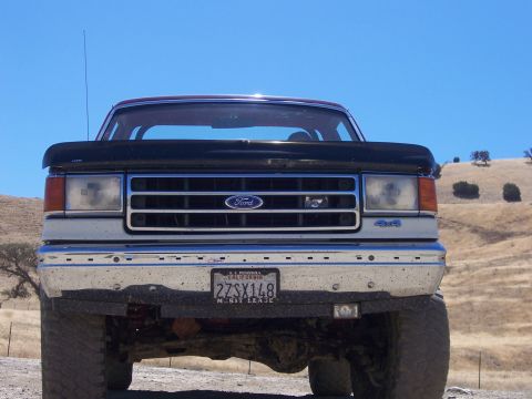 1991 Ford Bronco - Front view of a 1991 Ford Bronco parked outdoors with a clear blue sky.