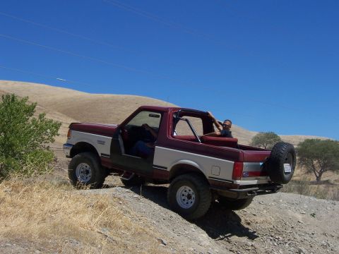 1991 Ford Bronco - Two-tone 1991 Ford Bronco with removable top is driven off-road.