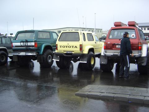1996 Ford Bronco - Three modified SUVs, including a Ford Bronco and two Toyotas, are parked together outdoors.