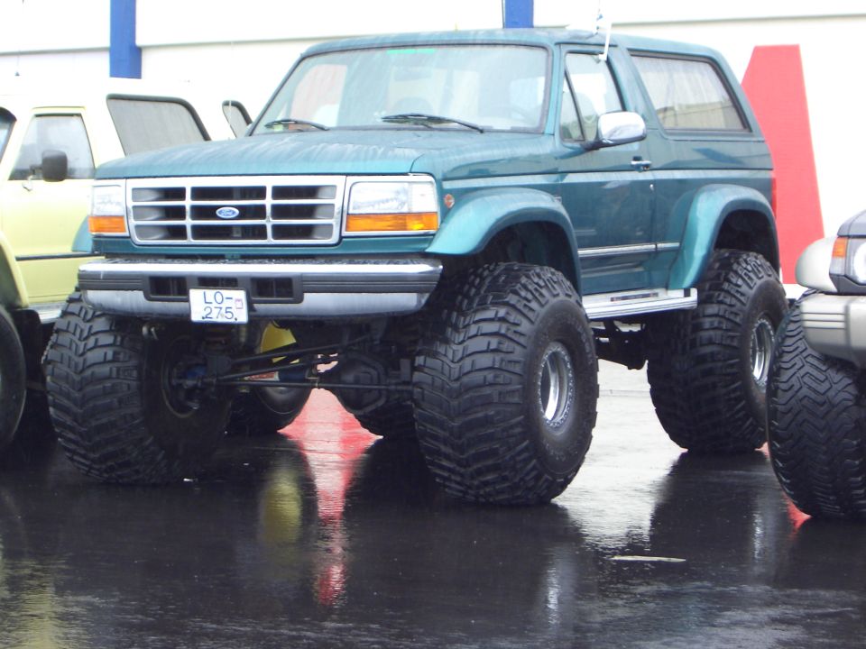 Heavily lifted teal Ford Bronco on large tires, BC plate