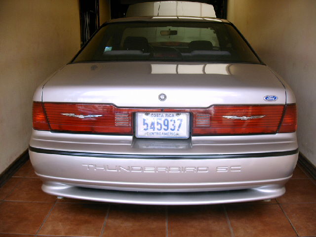 Rear of a silver Ford Thunderbird SC coupe in a tiled garage