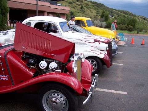 1972 Ford Ranchero - Multiple classic vehicles are lined up in a parking lot with a hilly background.