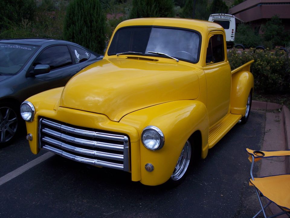 Yellow pickup truck with chrome grille, seen from a 3/4 front angle