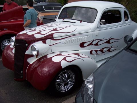 1972 Ford Ranchero - A classic coupe with custom flame paint is displayed at an outdoor car event.