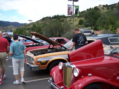 1972 Ford Ranchero - A 1972 Ford Ranchero is displayed with its hood open at a car show, its engine and wood-paneled sides.