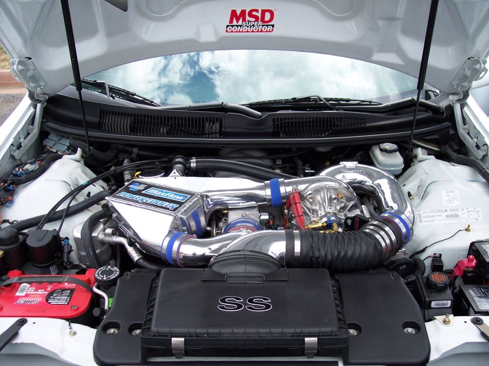 Engine bay with polished intake, intercooler, and turbocharger. 'SS' emblem visible on airbox