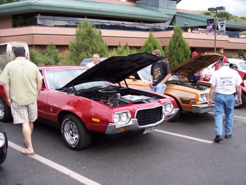 1972 Ford Ranchero - Red 1970 Ford Ranchero at a car show, hood open, parked next to a brown vehicle.