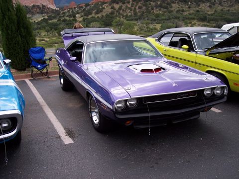 1972 Ford Ranchero - A purple Dodge Challenger is parked at a car show with other vehicles and a scenic mountain background.