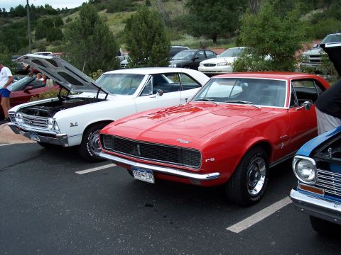 1972 Ford Ranchero - A red 1968 Chevrolet Camaro RS is parked at a car show with other vehicles visible.
