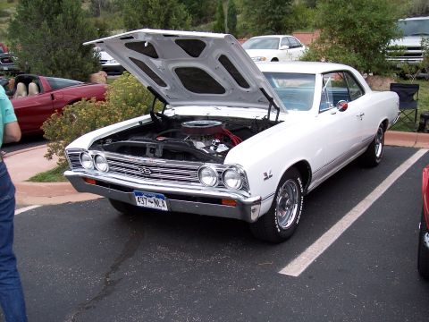 1972 Ford Ranchero - A white 1967 Chevrolet Chevelle SS coupe is parked with its hood open, revealing the engine. The license plate reads 437-NLA.