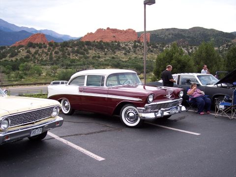 1972 Ford Ranchero - A 1956 Chevrolet Bel Air is parked at a car show with other vehicles and a scenic mountain backdrop.